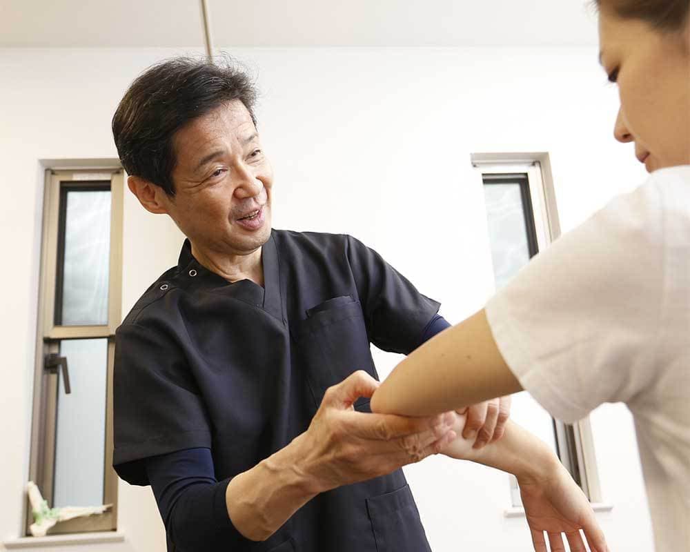 肘の部分を診察している様子